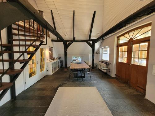 a barn hallway with a table and a staircase at Ferienhaus Heilhecker in Brake