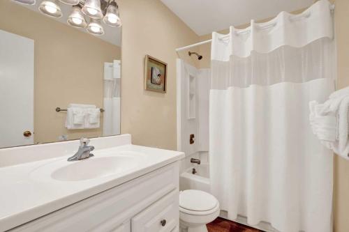 a white bathroom with a sink and a toilet at Lighthouse Point Rental 8B in Tybee Island