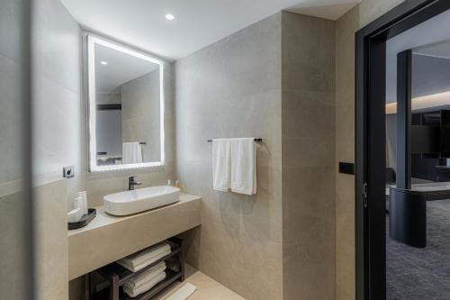 a bathroom with a sink and a mirror at Central Hotel in Ferizaj