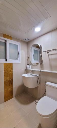 a bathroom with a sink and a toilet and a mirror at Vong Stay 봉스테이 in Chilgok