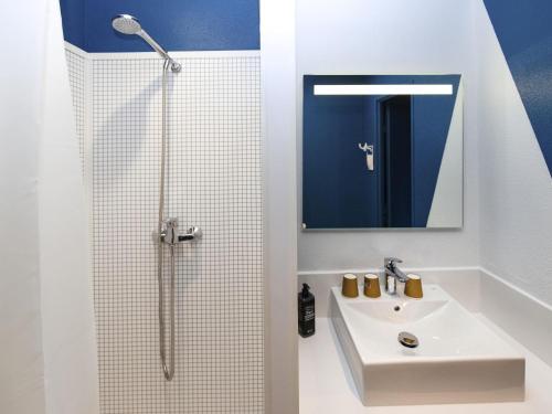 a white bathroom with a sink and a shower at ibis Budget La Teste Bassin d'Arcachon in La Teste-de-Buch