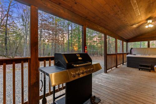 a grill on a screened porch of a cabin at Wide Glide Lodge - In-home Movie Room, Hot Tub and Large 1-acre property with Playset in Broken Bow