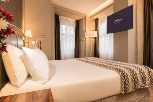 a hotel room with a bed and a tv at Dorma Almada Porto in Porto