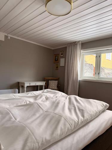a bedroom with a white bed and a window at Indreli feriehus in Flåm