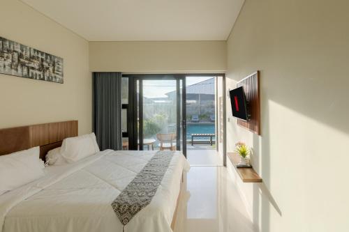 a bedroom with a large bed and a balcony at DC 08 Residence in Dalung
