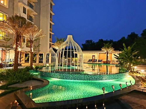 a swimming pool with a bird cage in front of a building at Panthashala Santiniketan in Srī Niketan