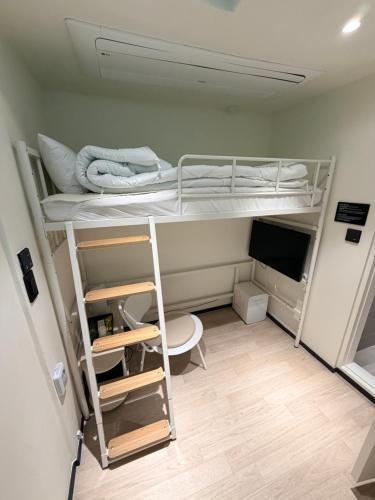 a small room with two bunk beds and a television at Regen Hotel in Seoul