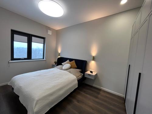 a bedroom with a bed and a window at Brúarárbyggð A2 in Blaskogabyggo