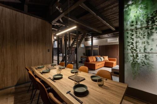 a long table in a room with chairs and a couch at Betsuan Private Villa in Kuwana