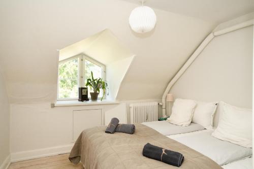a white bedroom with a bed and a window at Edelsminde Bed & Breakfast in Haslev