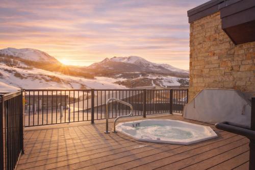 a hot tub on a deck with snow covered mountains at Skywalk Flats Mountainview Condo: Downtown, Rooftop Hot Tubs in Silverthorne