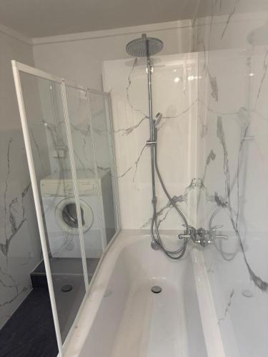 a bathroom with a tub with a shower and a washing machine at Ute Urbaner in Irschen