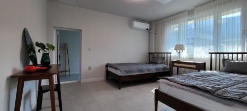 a bedroom with a bed and a desk and a window at Vong Stay 봉스테이 in Chilgok