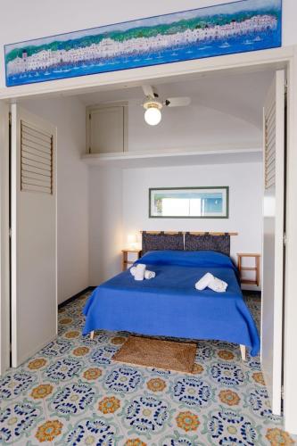 a bedroom with a bed with a blue comforter at Villetta La Conca in Conca dei Marini