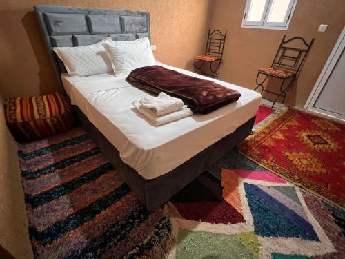 a bedroom with a bed with towels on it at Pergolas Tamakouchte in Ouarzazate