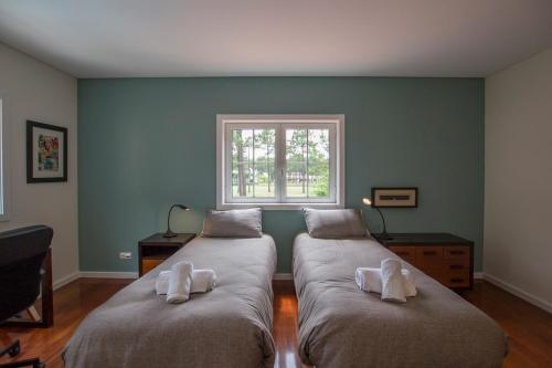 two large beds in a room with a window at Villa Buganvilia III in Aroeira
