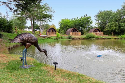 a statue of a bird standing in the water at Lakeside Nest - Fishing Lakes, Heated Outdoor Swimming Pool 500yrds on Sister Park , Pool Open May to September in Exeter