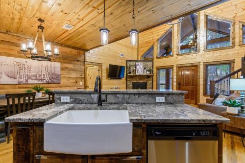 a kitchen with a large white sink in a cabin at Low Rider Lodge - Backs to Pine Forest and ATV Trail Access from Driveway in Broken Bow