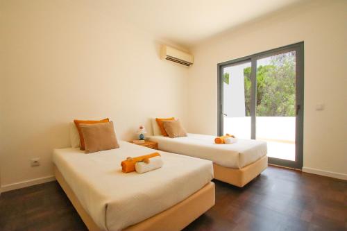a bedroom with two beds with stuffed animals on them at Villa Phi Phi - com piscina privada em Vilamoura in Quarteira