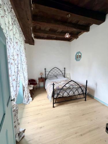 a bedroom with a bed and a wooden floor at La Maison d'Amélie à Arnac-Pompadour in Arnac-Pompadour