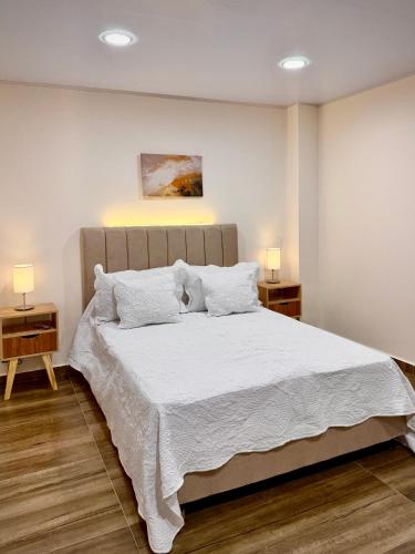 a bedroom with a large bed with white sheets and pillows at Amazonía Luxury in Florencia