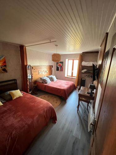 a bedroom with two beds and a table in it at Gîte de Jean-Benoit in Le Passage