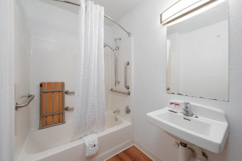 a white bathroom with a sink and a mirror at Varsity West in Centralia