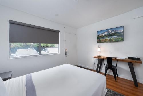 a bedroom with a bed and a desk and a window at Varsity West in Centralia