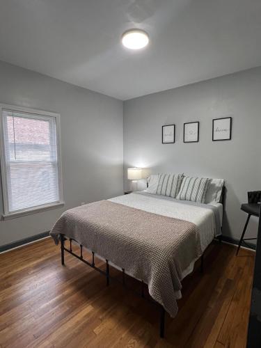 a bedroom with a large bed in a white room at Midtown Detroit Upper Retreat in Detroit