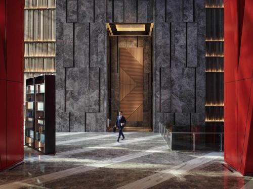 a man walking through a hallway in a building at Fairmont Ambassador Seoul in Seoul