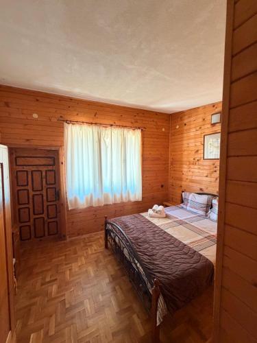 a bedroom with a bed in a wooden cabin at Guest House „ Mountain Rest“ in Lilyanovo