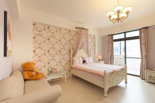 a teddy bear sitting on a couch in a bedroom at Happiness Homestay in Hualien City