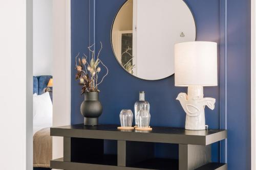 a room with a table with a lamp and a mirror at Ando Living - Abrantes 10 House in Lisbon
