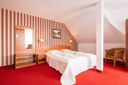 a bedroom with a white bed and a mirror at Bałtyk Resort in Rewal