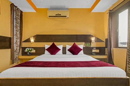 a bedroom with a large bed with red pillows at MGR Residency in Pondicherry