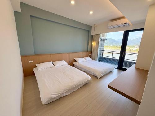 a bedroom with two beds and a large window at 八樂宿 包棟民宿 in Sanxing