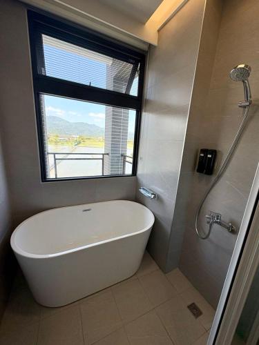 a white bath tub in a bathroom with a window at 八樂宿 包棟民宿 in Sanxing