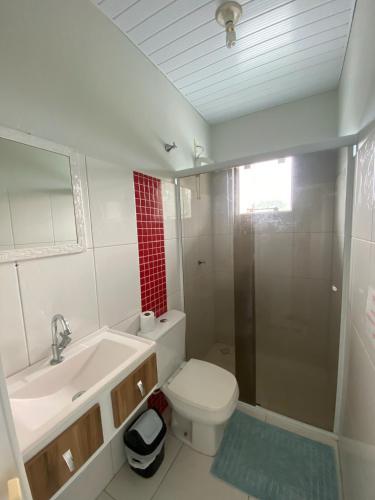 a bathroom with a toilet and a sink and a shower at Pousada Baia dos Golfinhos in Governador Celso Ramos
