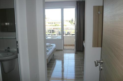 a bathroom with a sink and a tub and a window at Family Hotel PUDEV in Sunny Beach