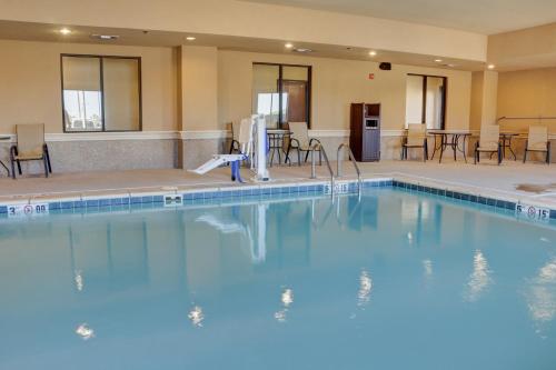 a large swimming pool with chairs and tables in a hotel at Holiday Inn Express Hotel & Suites Texarkana East by IHG in Texarkana