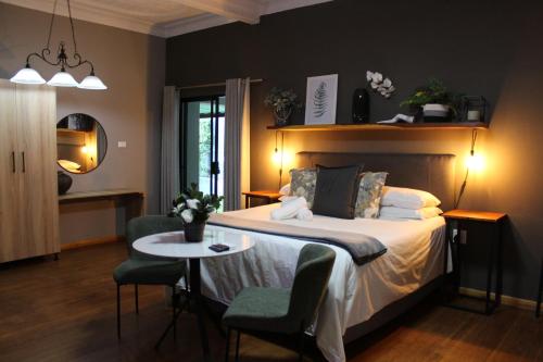 a bedroom with a bed with a table and chairs at Stay Local Potchefstroom in Potchefstroom