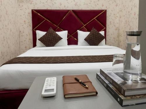 a hotel room with a bed and a table with a remote control at Hotel Cloud Inn in New Delhi