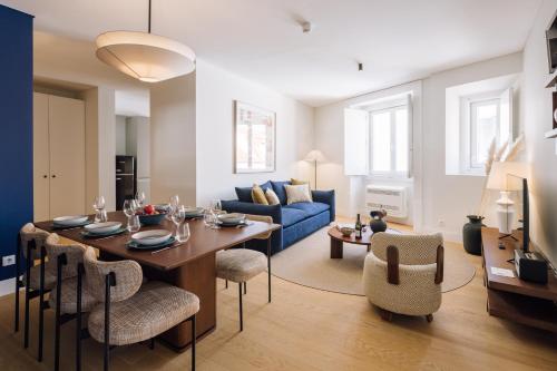 a living room with a table and a blue couch at Ando Living - Abrantes 10 House in Lisbon