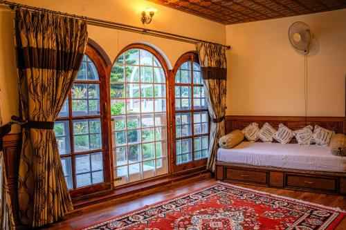 a bedroom with a bed and large windows at White House By Kulut in Shamshi