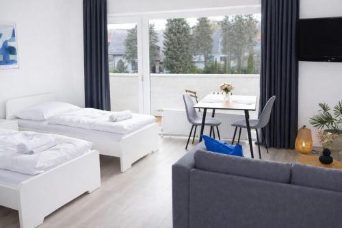 a living room with a couch and a table at Exklusive Studio-Apartments mit Balkon in Bad Rothenfelde