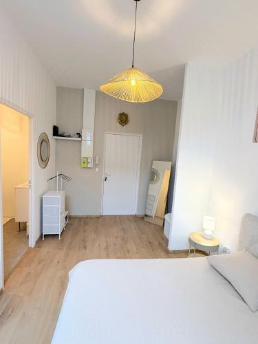 a bedroom with a bed and a yellow light at Studio Prestige, Cocon de Charme & Confort in Saint-Quentin