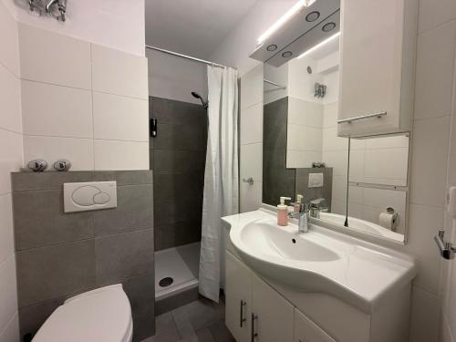 a bathroom with a white sink and a toilet at Exklusive Studio-Apartments mit Balkon in Bad Rothenfelde