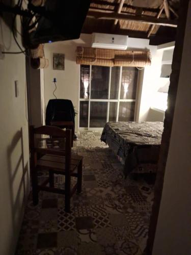 a room with a bed and a chair and windows at Anam Cara in Isla del Rincón
