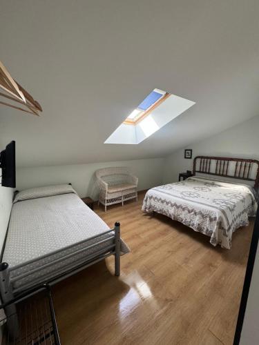a bedroom with two beds and a skylight at De Sol A Sol in Hornillos del Camino