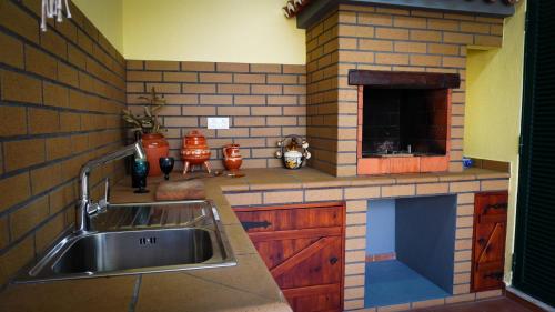 a kitchen with a sink and a stove at Villa Frente Mar by ESCAPE to Madeira in Funchal